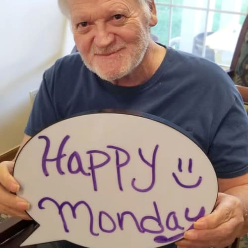 A resident holding a sign that says ' happy monday' at Creekside Village in Ponca City, Oklahoma