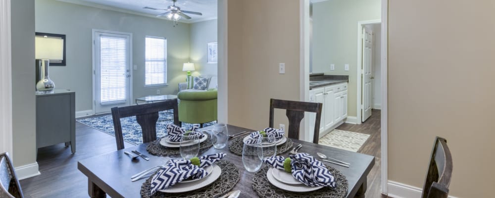 A decorated dining room table with a view of the living room and bathroom in an apartment at Brighton Park in Byron, Georgia 