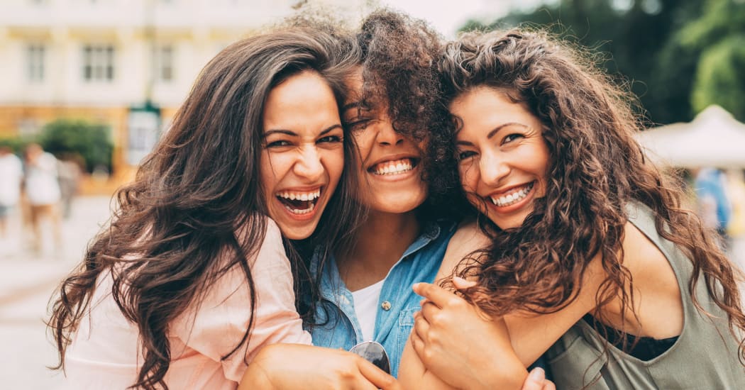 Friends hugging each other and smiling at Watercourse Apartments in Graham, North Carolina