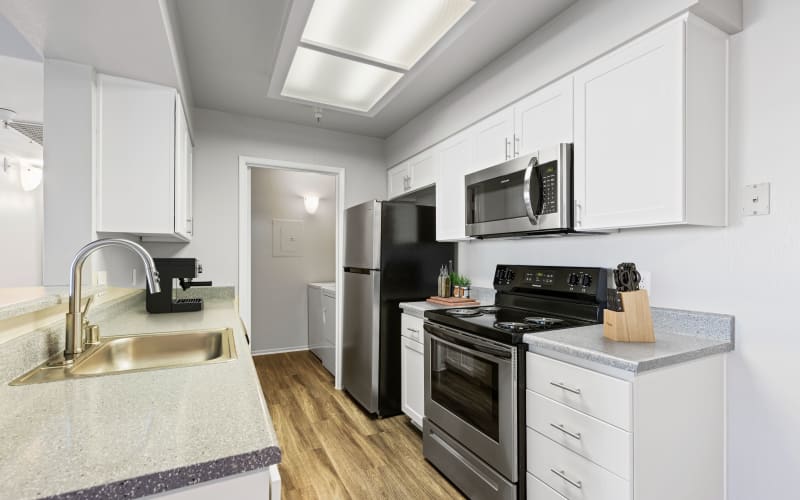 Ample counter space in a kitchen overlooking a dining room at Sierra Del Oro Apartments in Corona, California