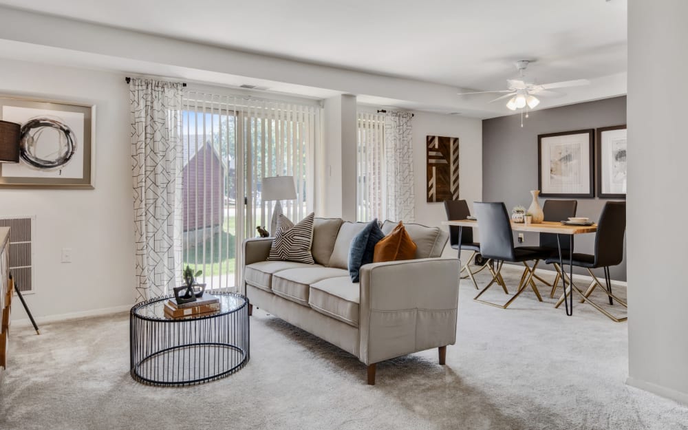 Living room and dining area with sliding door access to a private balcony at Columbia Pointe Apartment Homes in Columbia, Maryland