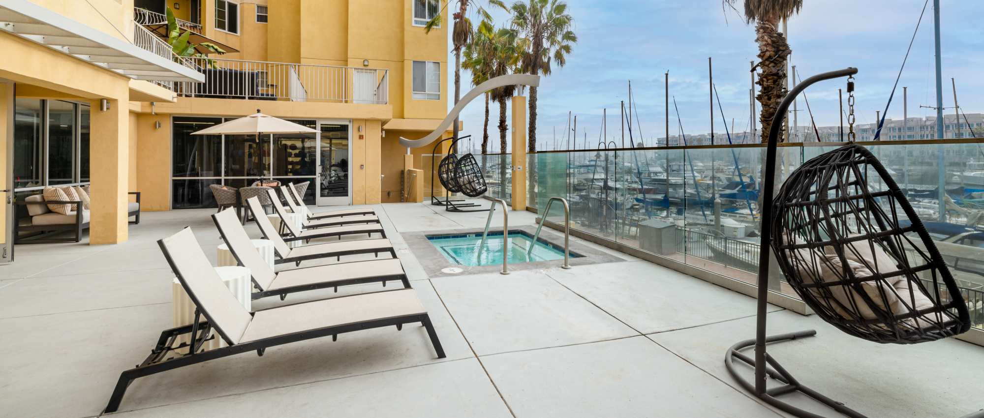 Lounge chairs and hanging chair by hot tub at St Tropez Apartments in Marina Del Rey, California