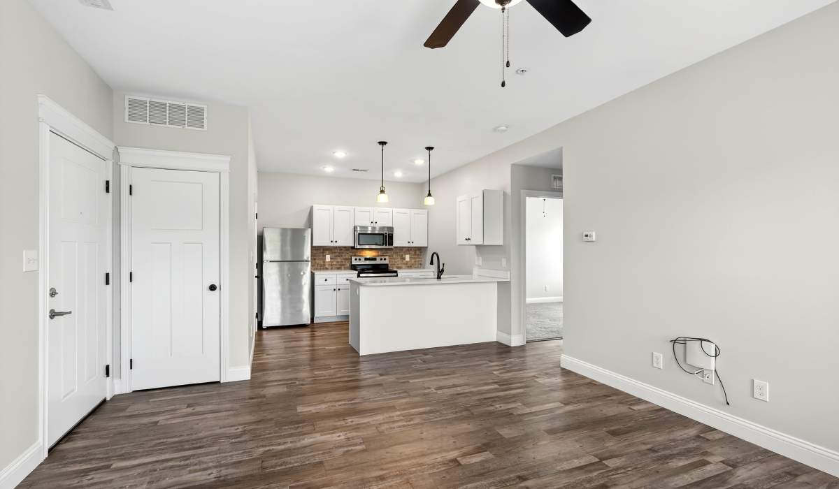 Unfurnished living room with wood-style flooring and view to kitchen at Palomar Woods in Lexington, Kentucky