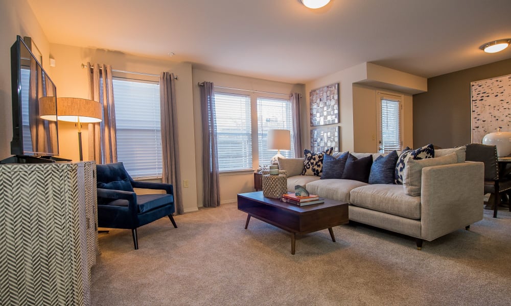 Spacious, bright living room with plush carpeting at Watercress Apartments in Maize, Kansas
