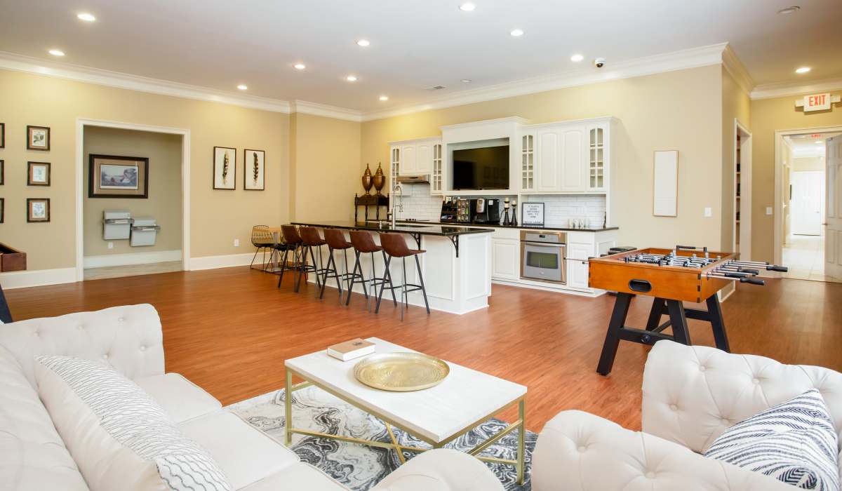 Community clubhouse living space with connecting kitchen at Madison Park in Madison, Alabama