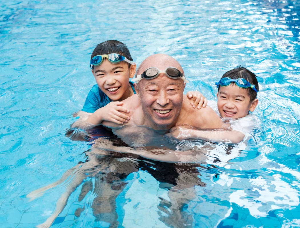 Family swimming in pool at Avenida Cool Springs in Franklin