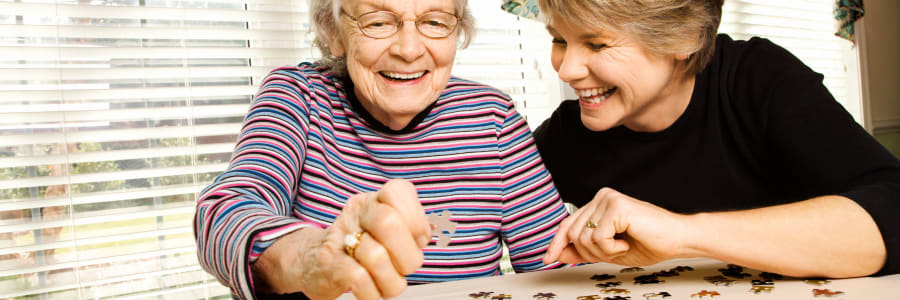 Resident sitting and talking with a caretaker at Bell Tower Residence Assisted Living in Merrill, Wisconsin