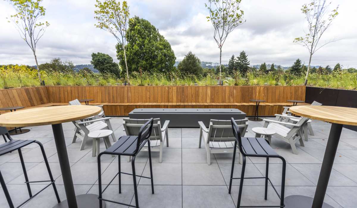 Outdoor dining patio with communal tables and seating at Brookland Apartments in Portland, Oregon