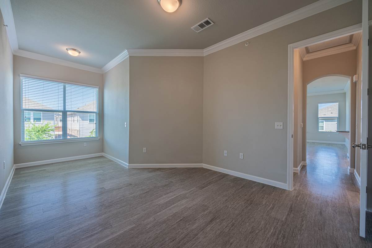 Unfurnished bedroom with large window and wood flooring at Century Travesia in Austin, Texas