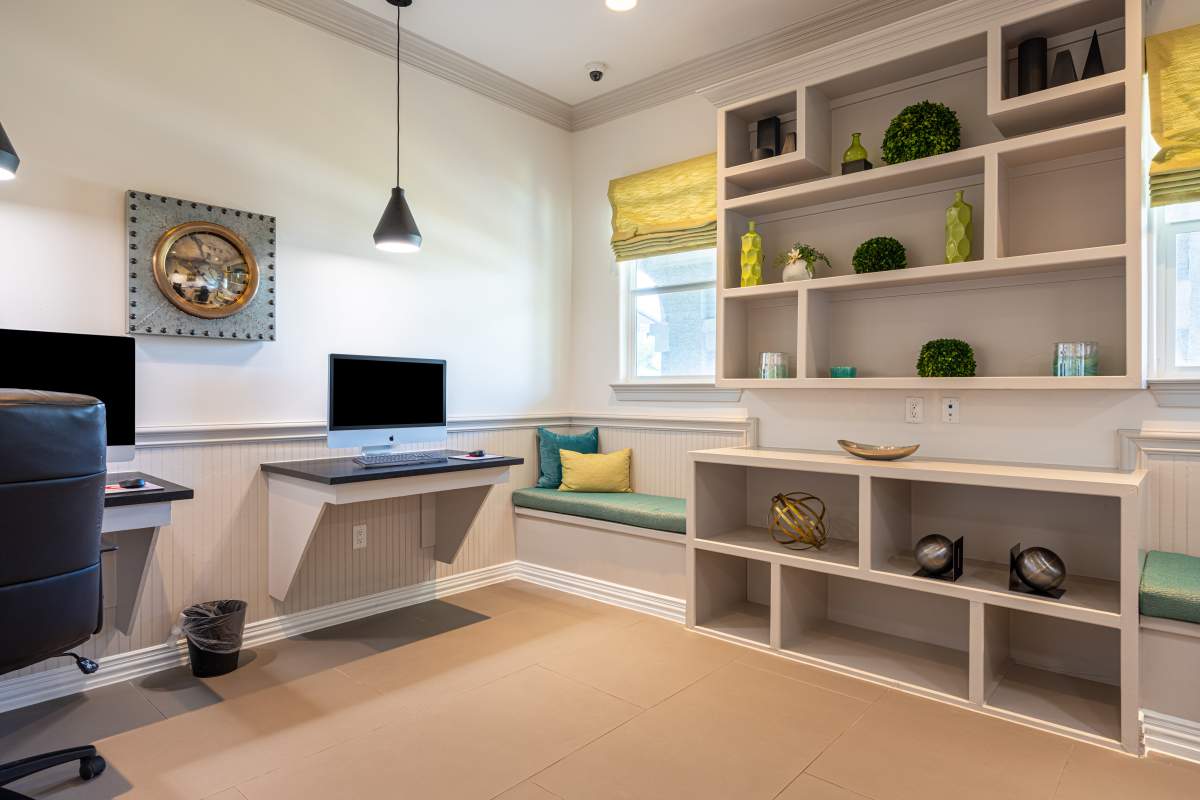 Community work space with computer and seating area at Century Travesia in Austin, Texas