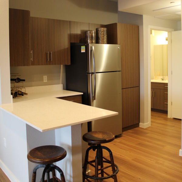 Kitchen with a small breakfast bar and stainless-steel fridge at The Maxx 159 in Goodyear, Arizona