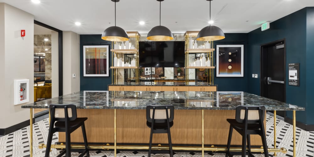 Kitchen with an island and bar seating in the community lounge at Lincoln Landing in Hayward, California