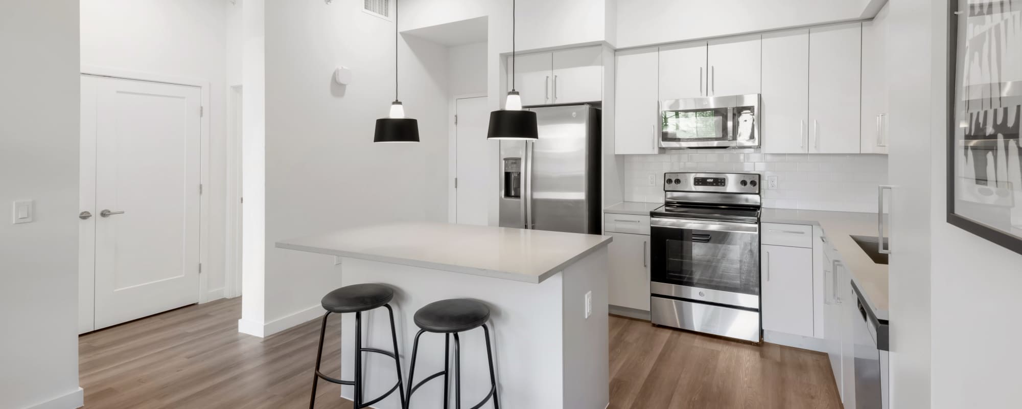 Bright kitchen with white cabinetry at Residences Of Highland in Hialeah, Florida
