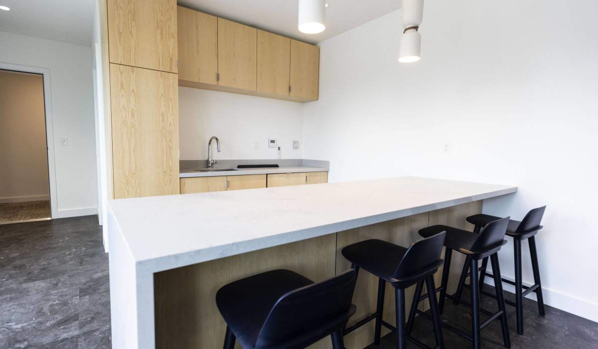 Kitchen with breakfast bar seating and modern finishes at Brookland Apartments in Portland, Oregon