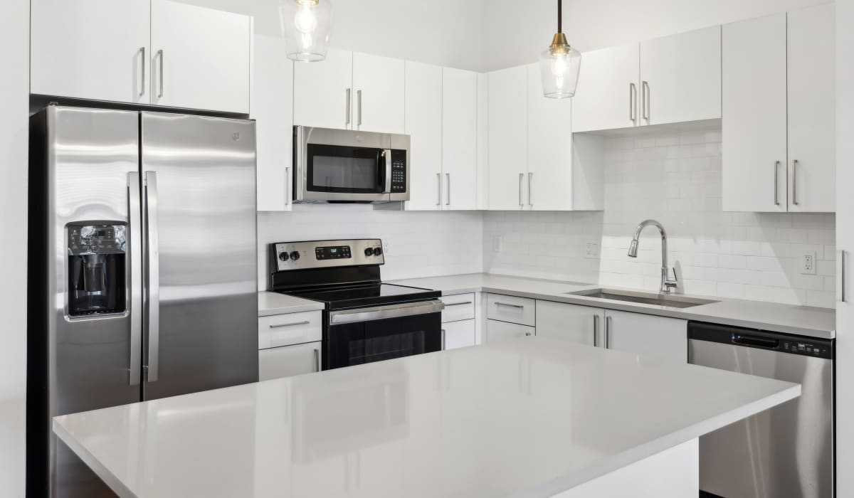 Kitchen with natural granite-stone countertops at Residences Of Highland in Hialeah, Florida
