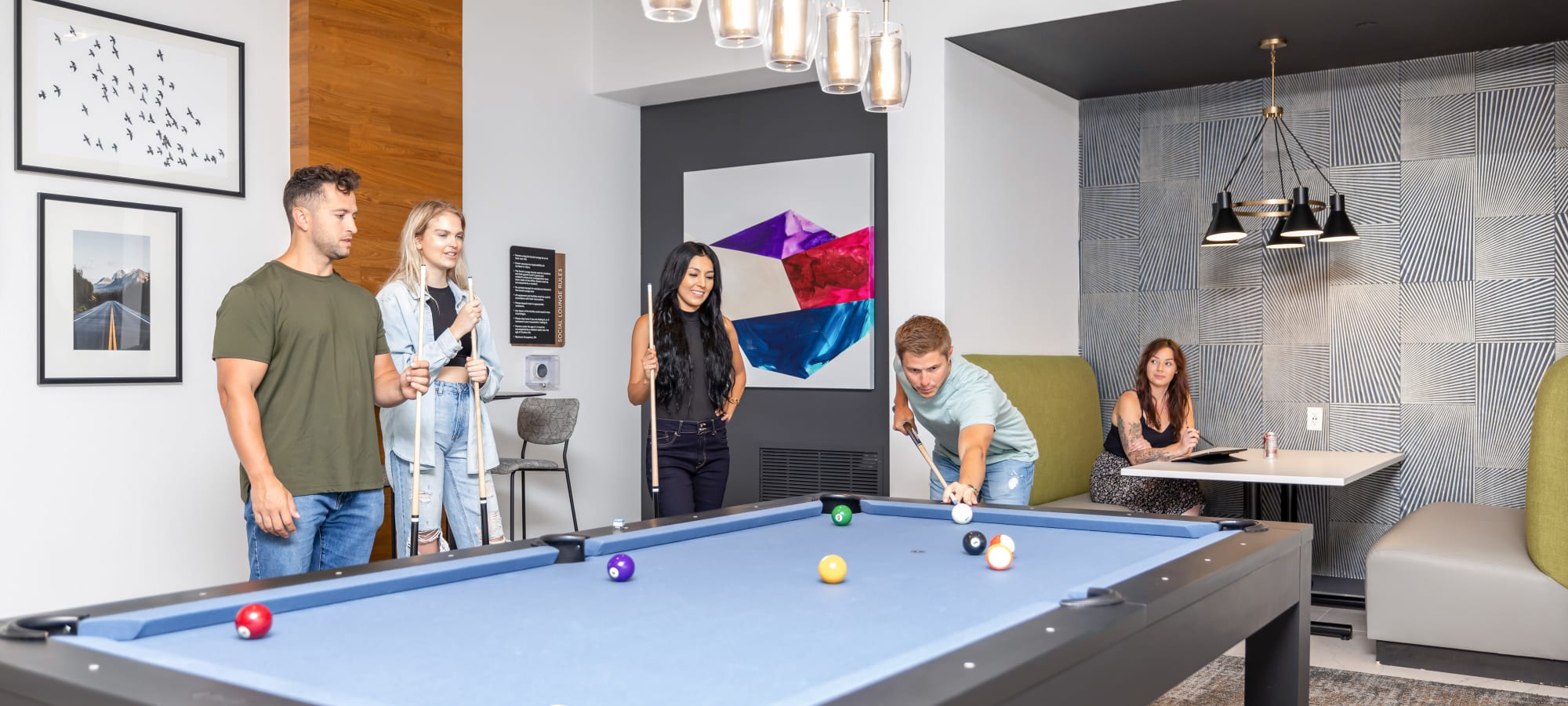 Residents playing pool in clubhouse at Marq Promenade in Westminster, Colorado