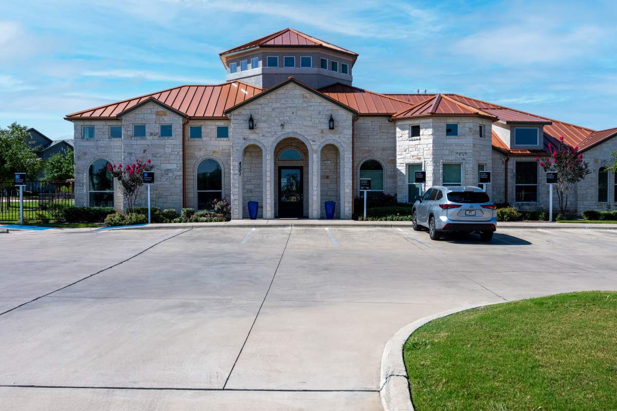Exterior view of the community with parking at Century Travesia in Austin, Texas