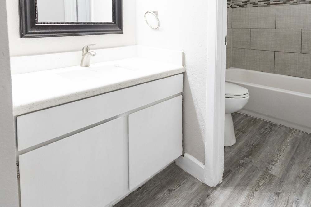 Charming bathroom with sleek white cabinetry and modern fixtures at San Mateo Forest in Dallas, Texas.