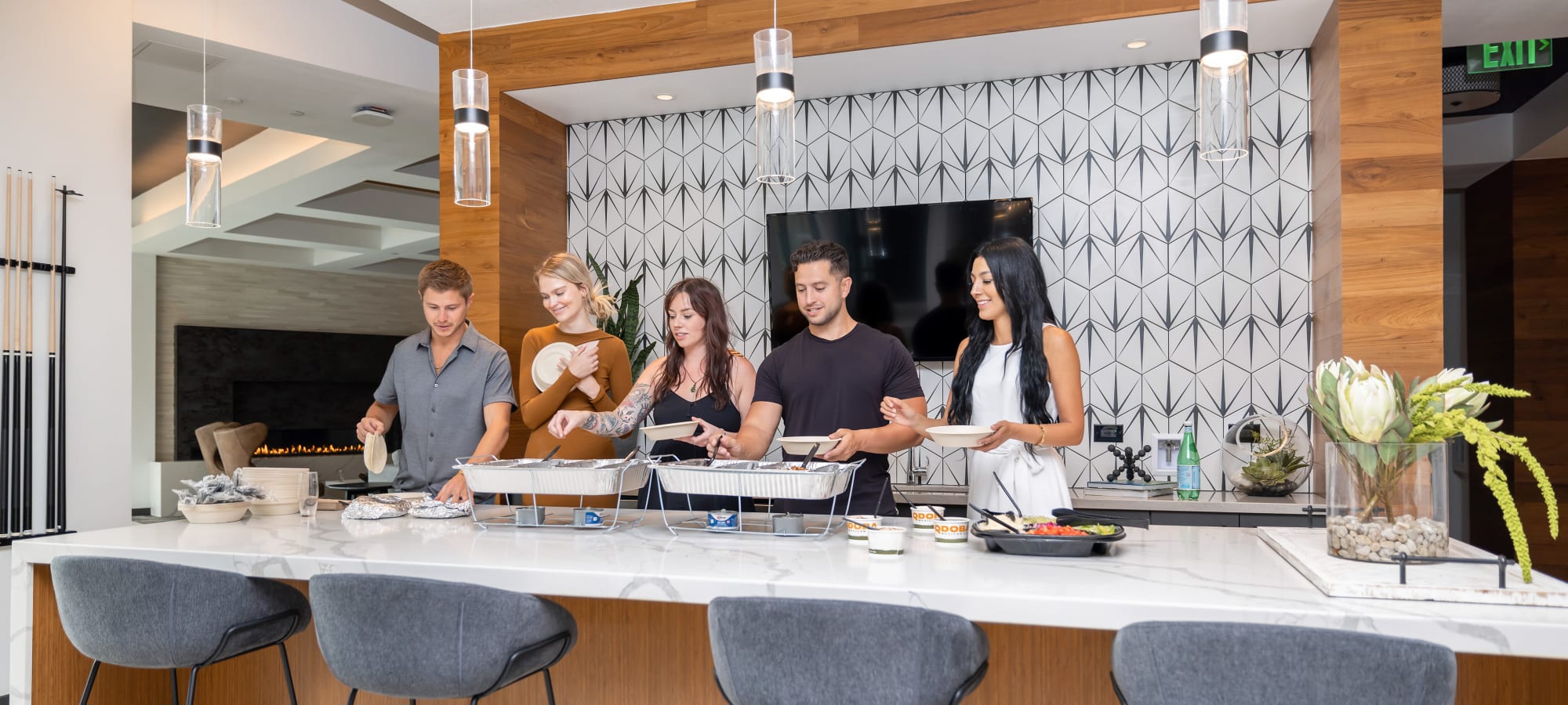 Residents in demo kitchen making a plate of food at Marq Promenade in Westminster, Colorado