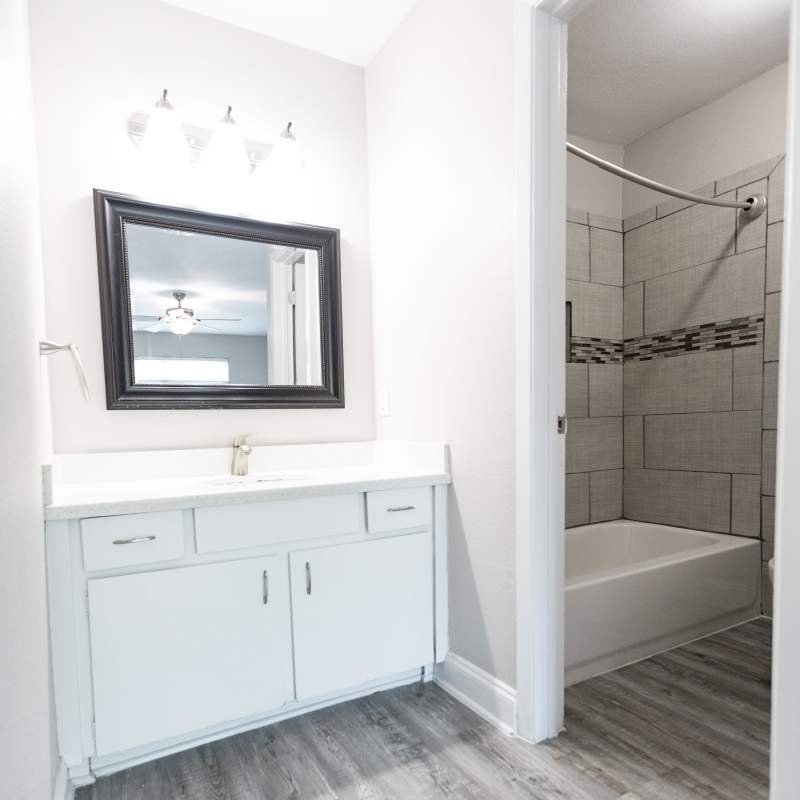 Elegant bathroom retreat featuring a chic vanity, stylish tile accents, and a soothing shower space at San Mateo Forest in Dallas, Texas