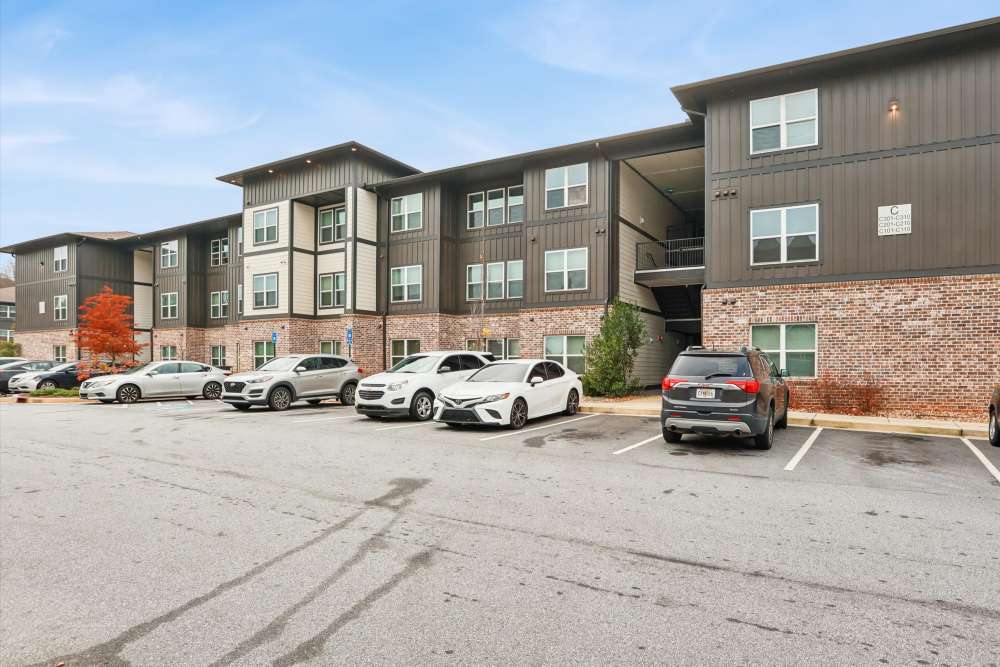 Exterior view of the apartments showing cars parked at Flats at Mount Zion in Stockbridge, Georgia