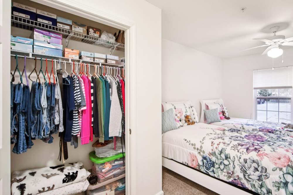 Bright bedroom with floral bedding and organized closet space at Villas At Meadow Springs in Ankeny, Iowa