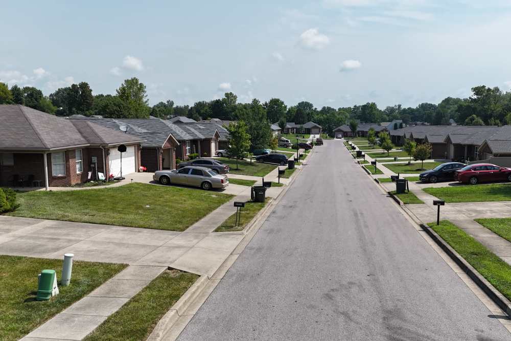 Quiet suburban street lined with tidy homes and green lawns at Aberdeen Woods in Jeffersonville, Indiana