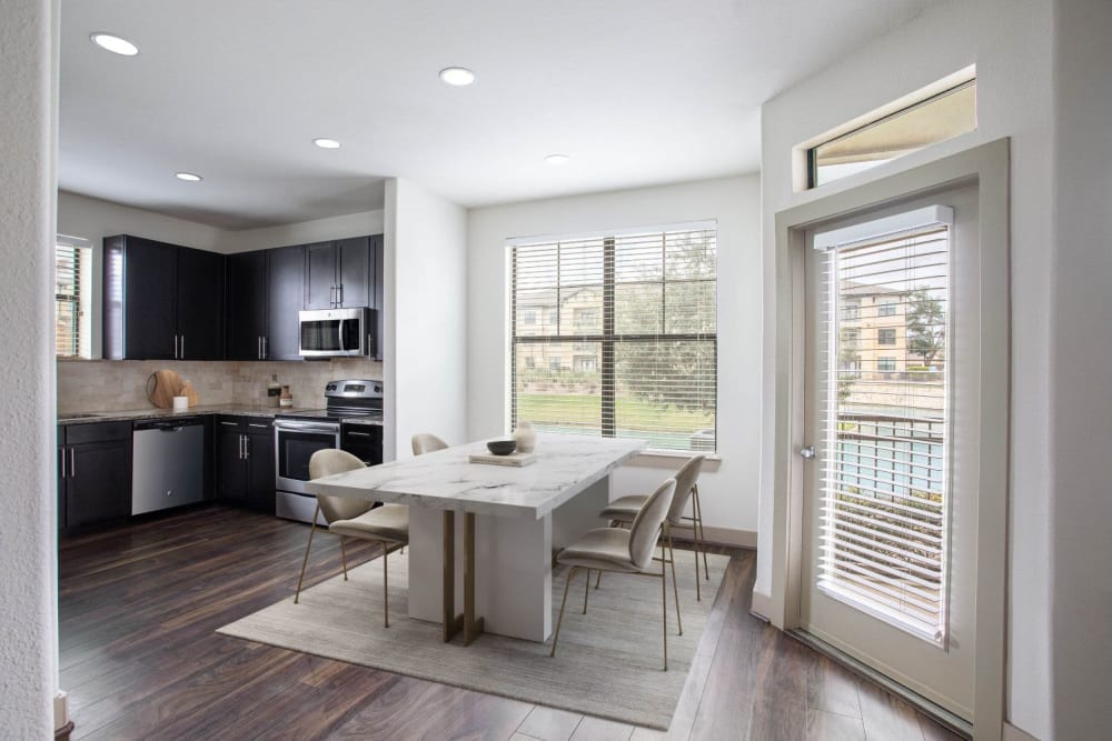 Dining table next to large open kitchen at Olympus Falcon Landing in Katy, Texas