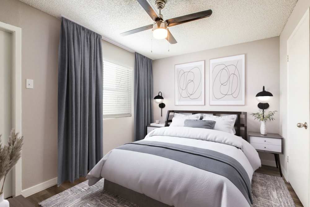 Bedroom with large window, curtain and side lamp at Villa De Oro in San Antonio, Texas