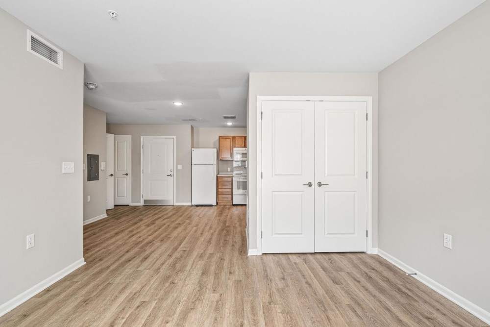 Open layout with wood-style flooring, modern kitchen featuring stainless steel appliances and light wood cabinets at Black Rock Crossing in Marquette, Michigan