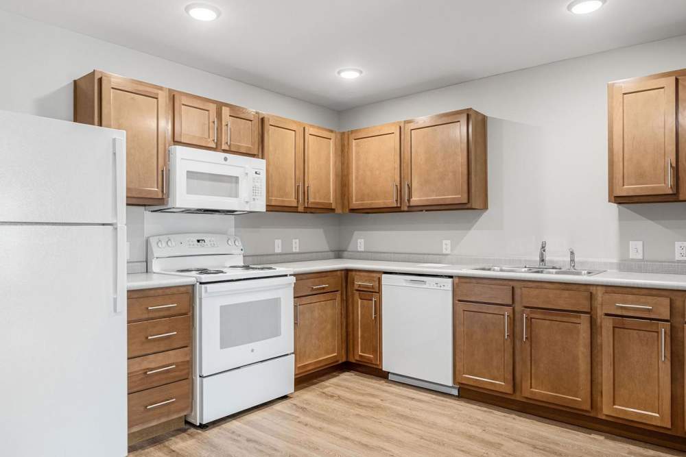 Modern kitchen with granite countertops, stainless steel appliances, and wood-style flooring at Black Rock Crossing in Marquette, Michigan