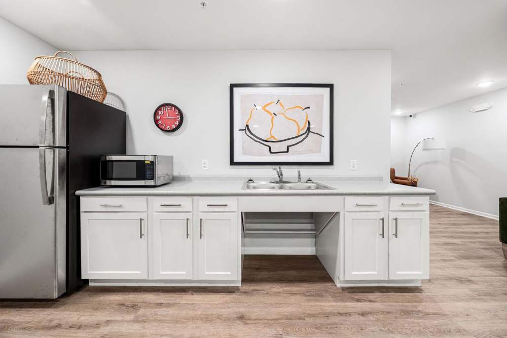 Modern kitchen with stainless steel appliances, granite countertops, white cabinetry, and wood-style flooring at Black Rock Crossing in Marquette, Michigan