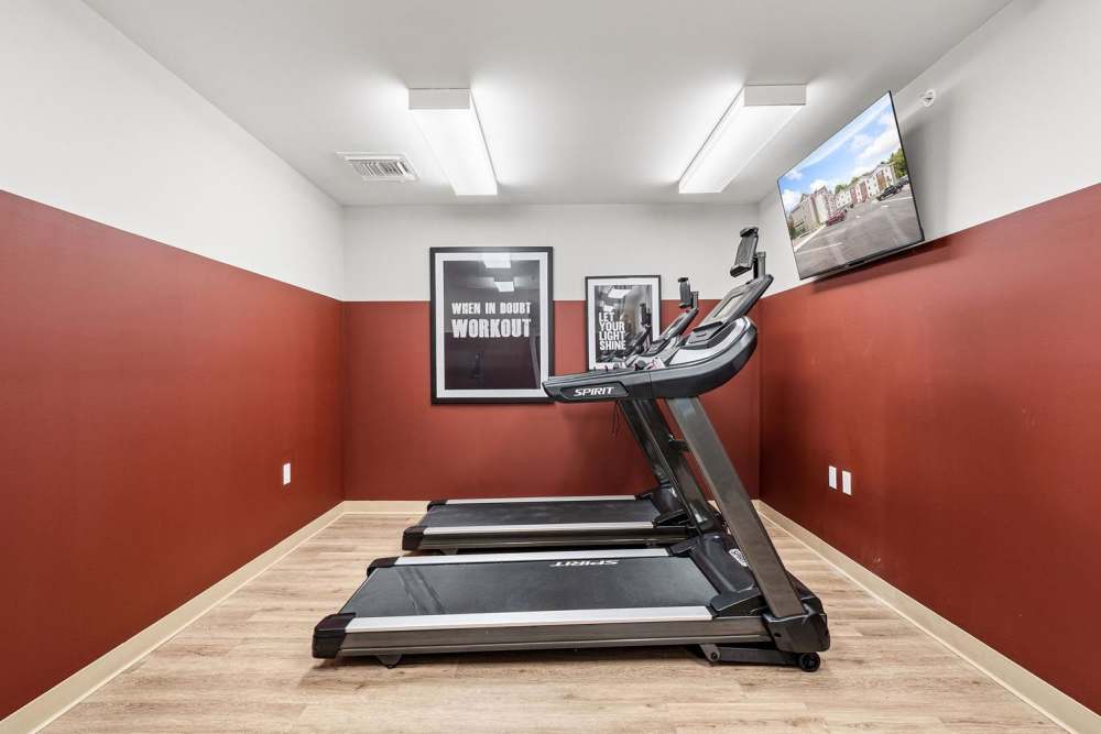 Fitness center with two treadmills and motivational wall art, wood-style flooring, bright lighting at Black Rock Crossing in Marquette, Michigan