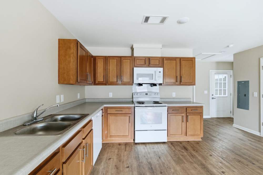 Kitchen with wooden cabinets and granite countertops at Carmichael Commons in Madison, Georgia