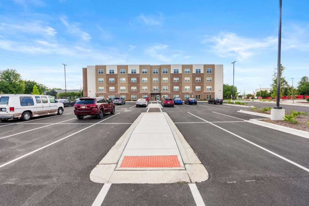 Exterior view of apartment building with car parking at Deville Manor in Oswego, Illinois