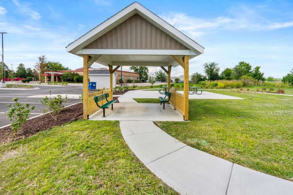 Beautifully land scaped garden with community seating area for residents at Deville Manor in Oswego, Illinois