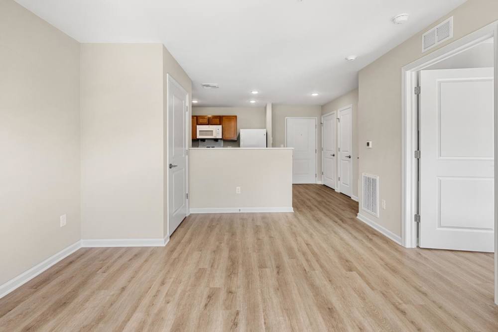 Well-lit apartment living room with open kitchen at Deville Manor in Oswego, Illinois