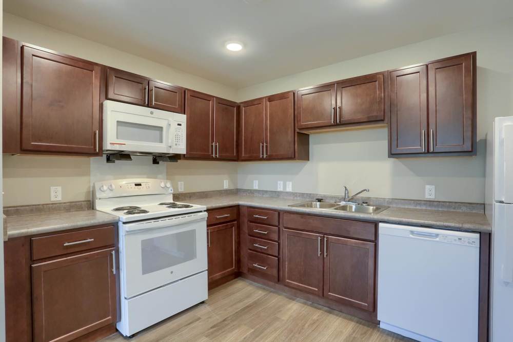 Modern kitchen featuring wooden cabinets and stainless steel appliances at Normandy Lofts in Shippensburg, Pennsylvania