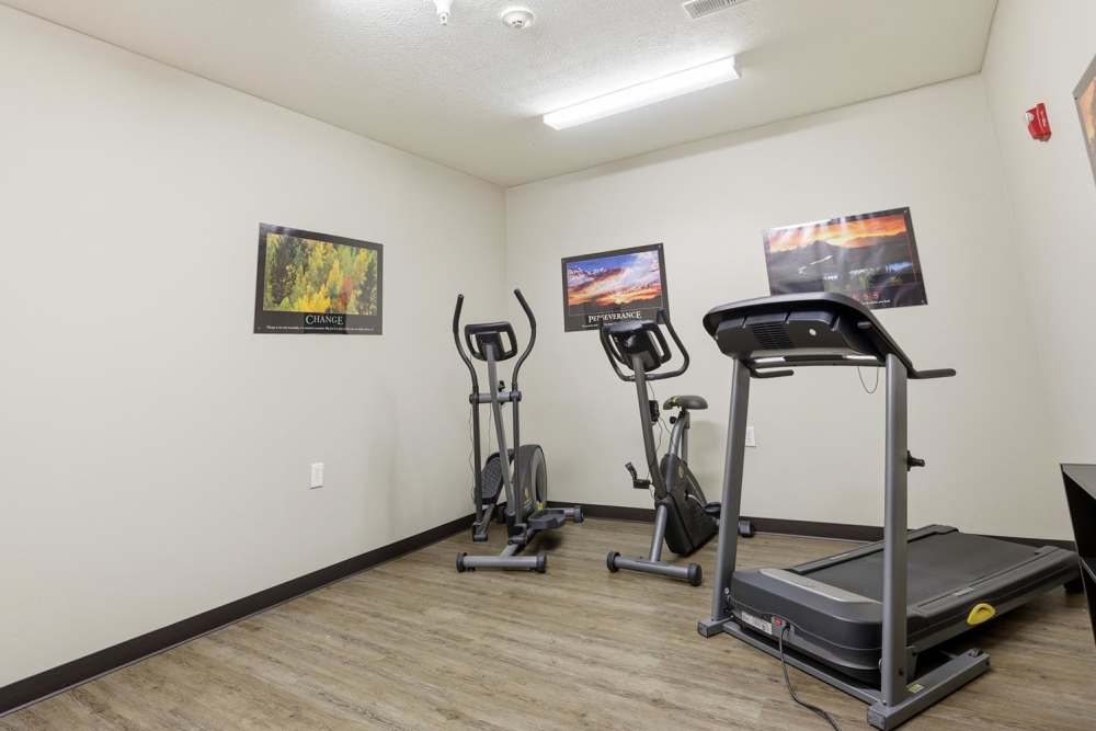 Fitness room with wood-style flooring and exercise equipment against neutral walls at Norwood Greene Senior Living in Marietta, Ohio
