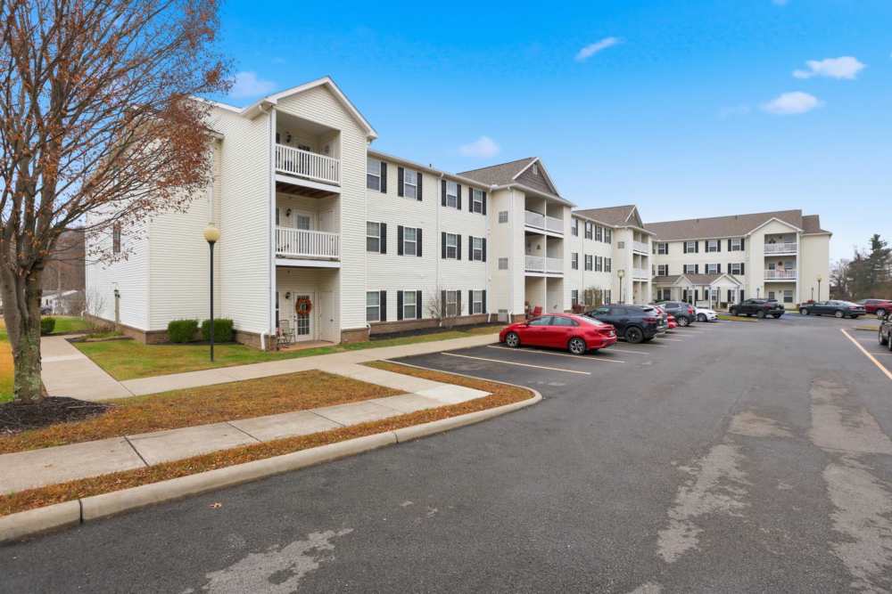 Multi-story apartment buildings with balconies and landscaped pathways in a parking lot at Norwood Greene Senior Living in Marietta, Ohio
