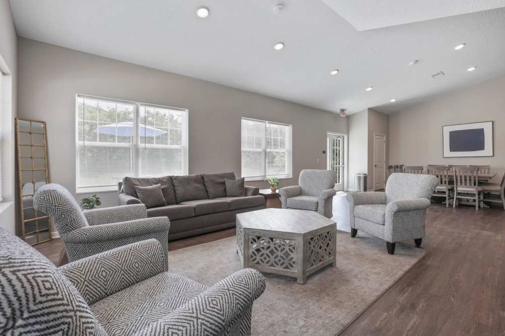 Bright community lounge with comfortable seating, large windows, and a dining area at Wheatland Crossing II in Columbus, Ohio