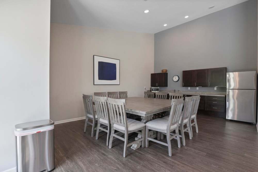Spacious community dining area with wood-style flooring and modern kitchen appliances at Wheatland Crossing II in Columbus, Ohio