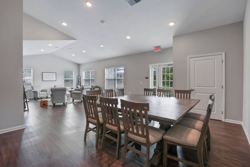 Spacious open layout with wood-style flooring and dining table for gatherings at Wheatland Crossing II in Columbus, Ohio