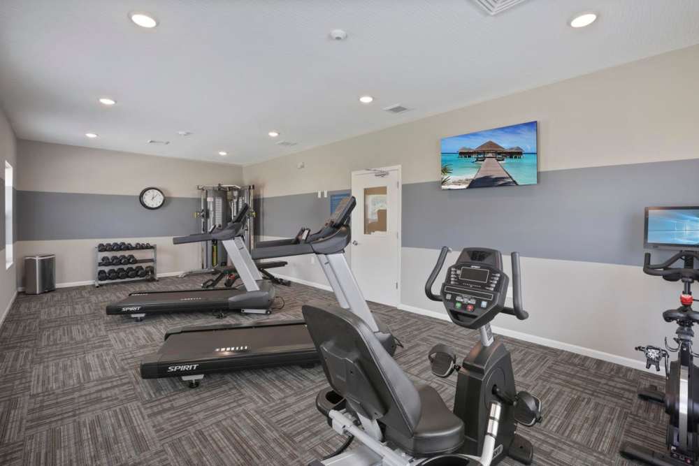 Modern fitness center with treadmills, stationary bikes, free weights, and motivational wall art at Wheatland Crossing II in Columbus, Ohio