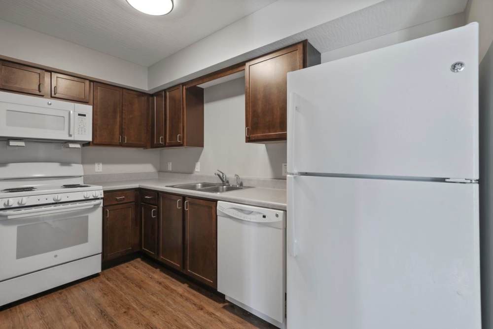 Kitchen featuring dark wood cabinets, stainless steel appliances, and wood-style flooring at Wheatland Crossing II in Columbus, Ohio