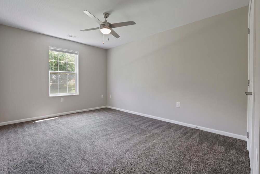 Spacious bedroom with carpet flooring, ceiling fan, and large window for natural light at Wheatland Crossing II in Columbus, Ohio