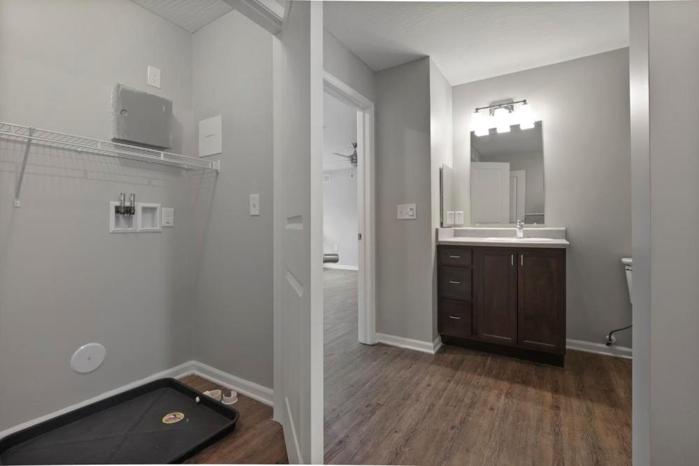 Laundry area with wood-style flooring, modern vanity, and open layout leading to living space at Wheatland Crossing II in Columbus, Ohio