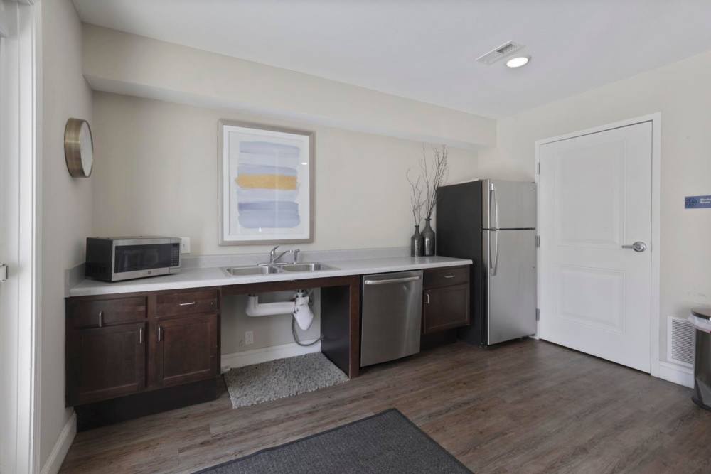 Modern kitchen with stainless steel appliances, granite countertops, and wood-style flooring at Wheatland Crossing II in Columbus, Ohio