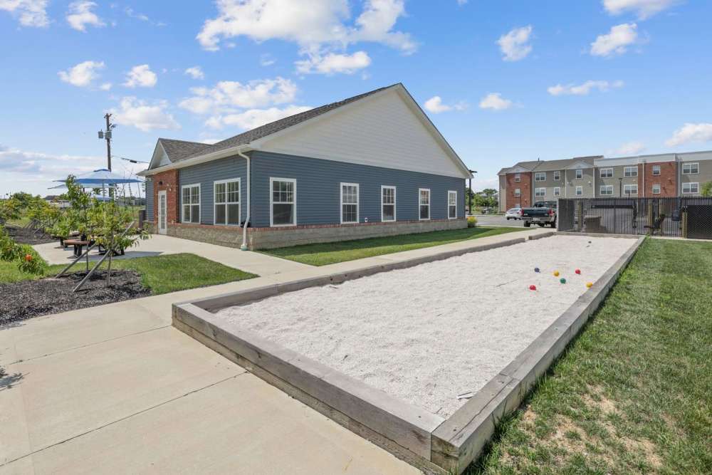 Community building with picnic area and bocce ball court surrounded by green grass at Wheatland Crossing II in Columbus, Ohio