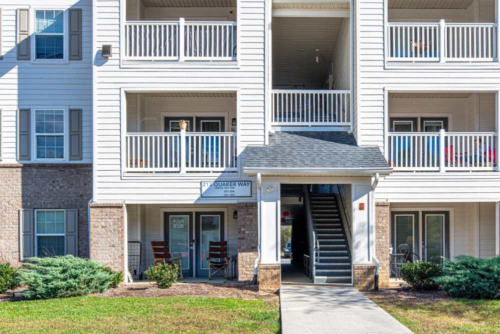 Three-story apartment building with balconies, inviting entrance, and landscaped greenery at White Oak Crossing in Knoxville, Tennessee